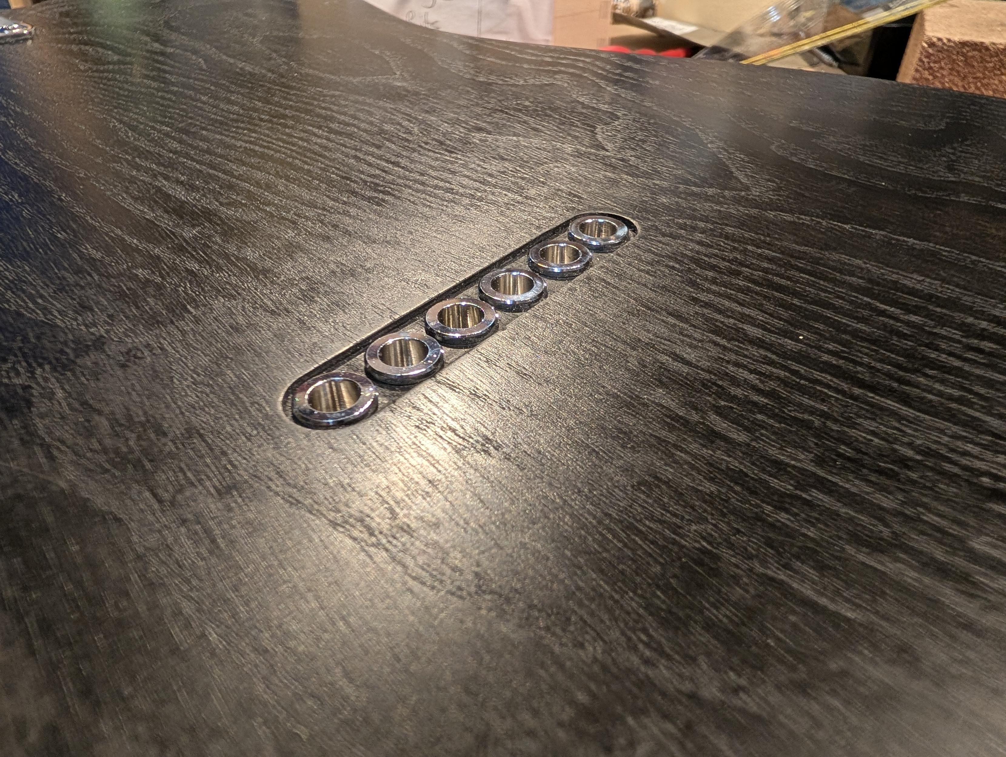 Picture of string ferrules in a guitar body.